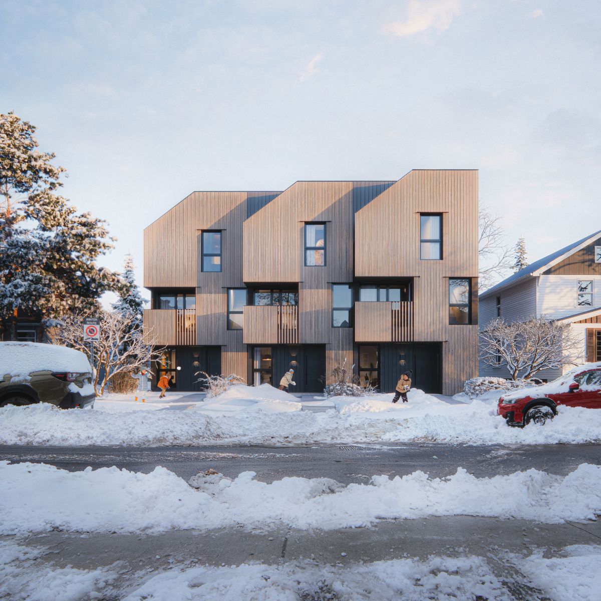 Rendu 3D d’un complexe de maisons en rangée de trois étages dotées d’une façade en bois clair, de grandes fenêtres et de balcons privés. La conception épurée et géométrique de l’immeuble se fond dans le quartier. 